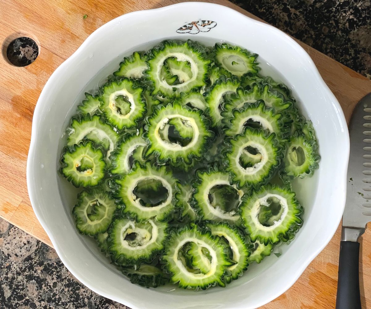 Sliced bitter gourd is in the bowl of water.