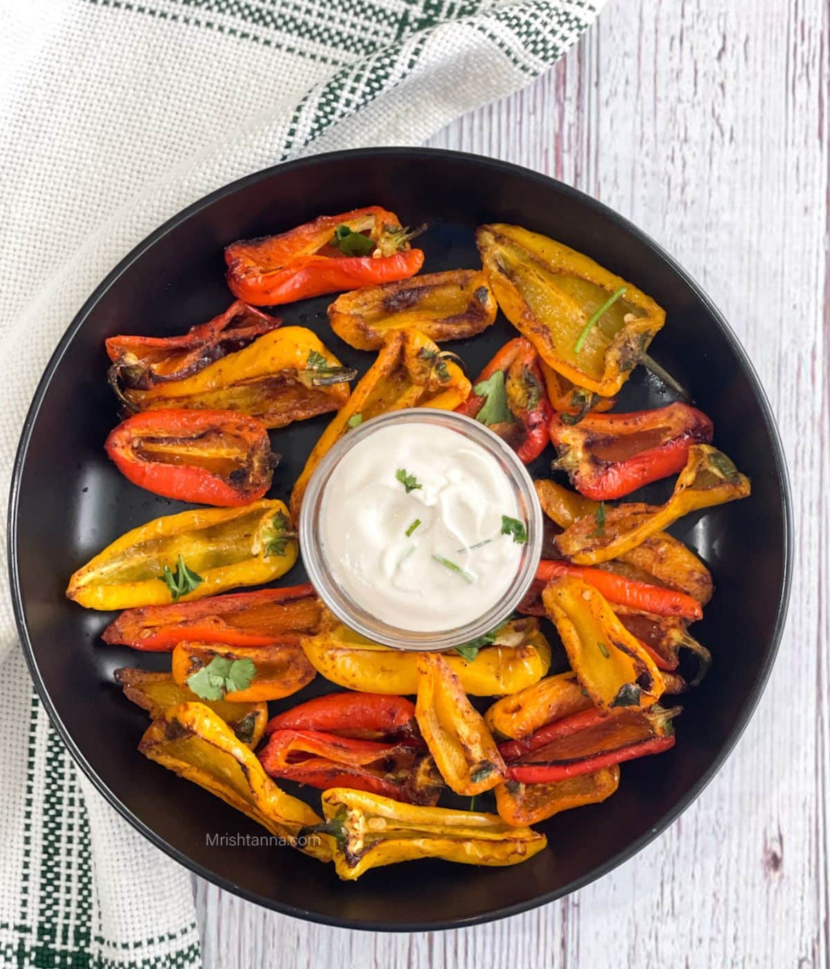 head shot of roasted mini peppers and a bowl of vegan dip.