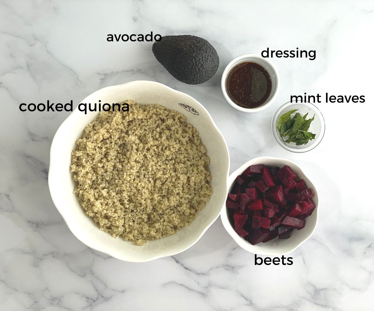 A table is with quinoa and beets salad ingredients.