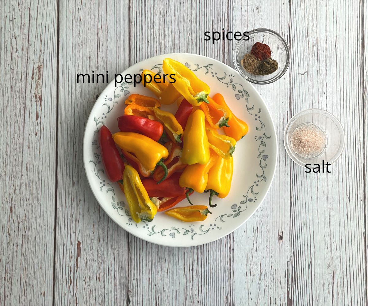 Recipes of roasted mini peppers ingredients are on the table.