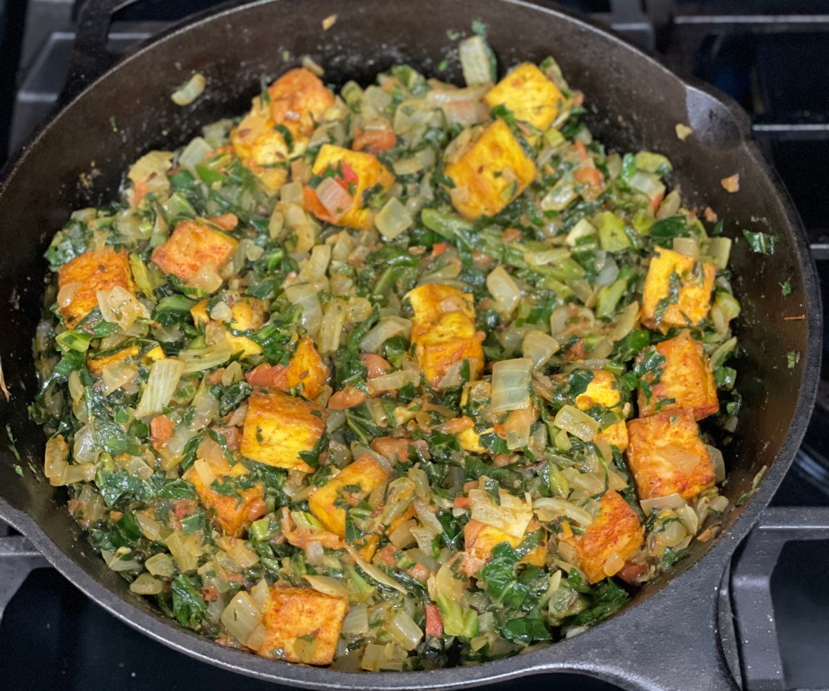 A large skillet is with vegan saag paneer.