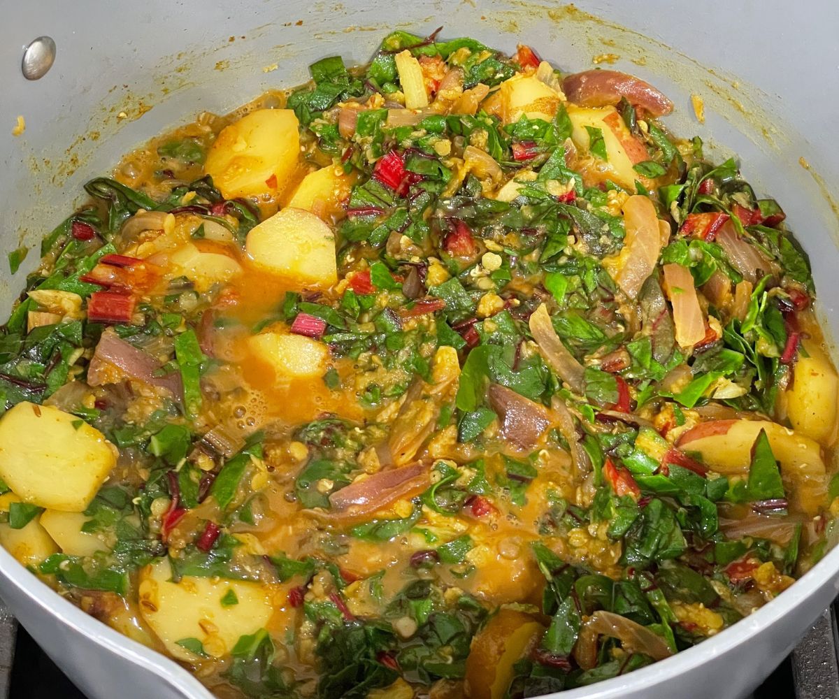 A pot of swiss chard curry over the heat.