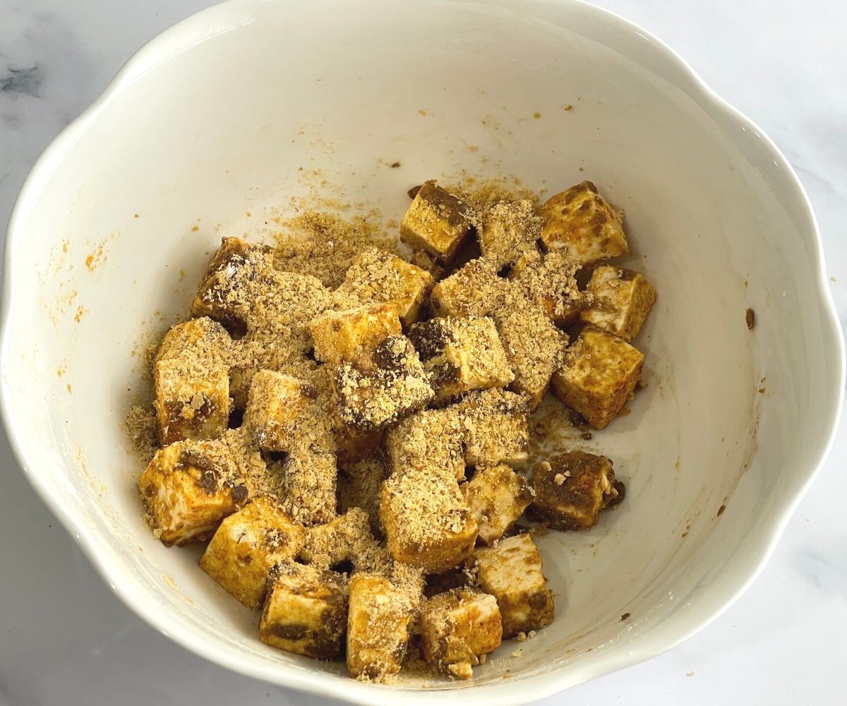 A bowl of tofu nuggets coated mixture is on the table.