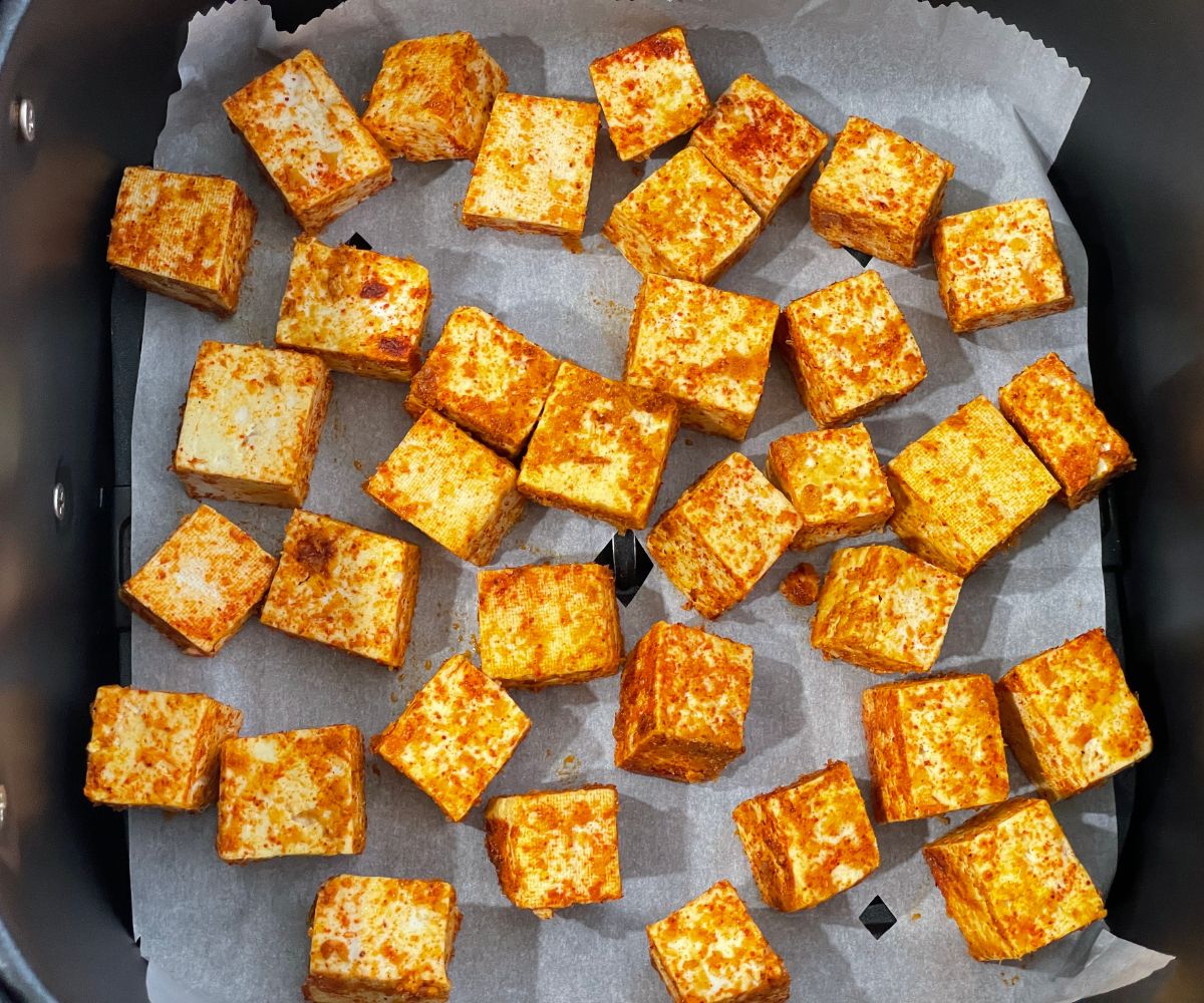 Air fryer basket is with spiced tofu.