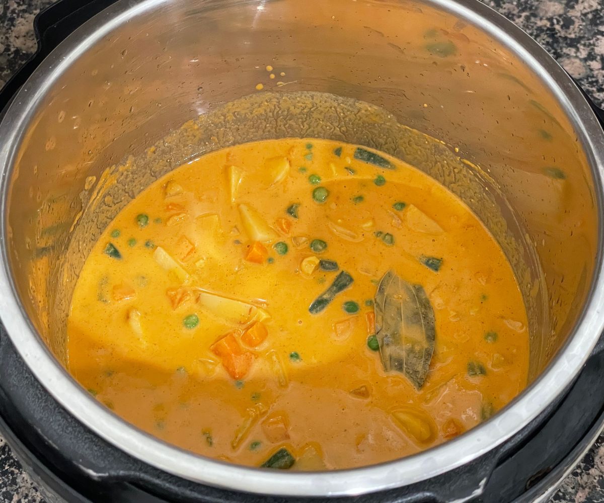 An instant pot is with vegetable korma on cooking setting.