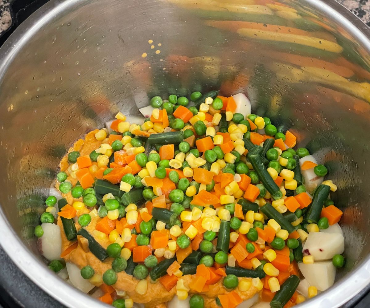 A pot with kurma masala and mixed vegetables.