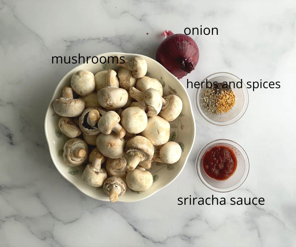 Mushrooms and onion, and other spices are on the table.