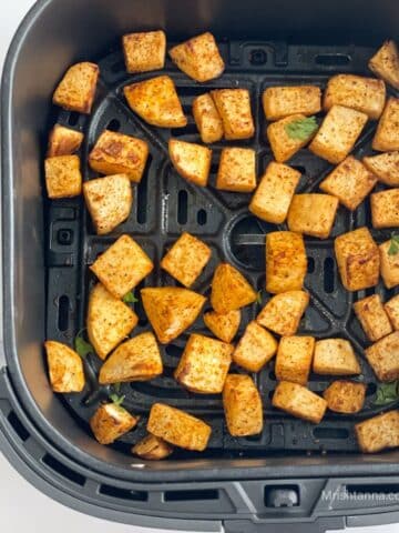 Air fryer roasted turnips is inside the air fryer basket.