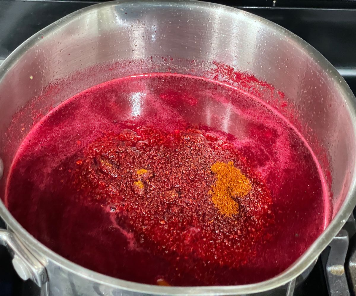 A pot is with beetroot rasam over the heat.