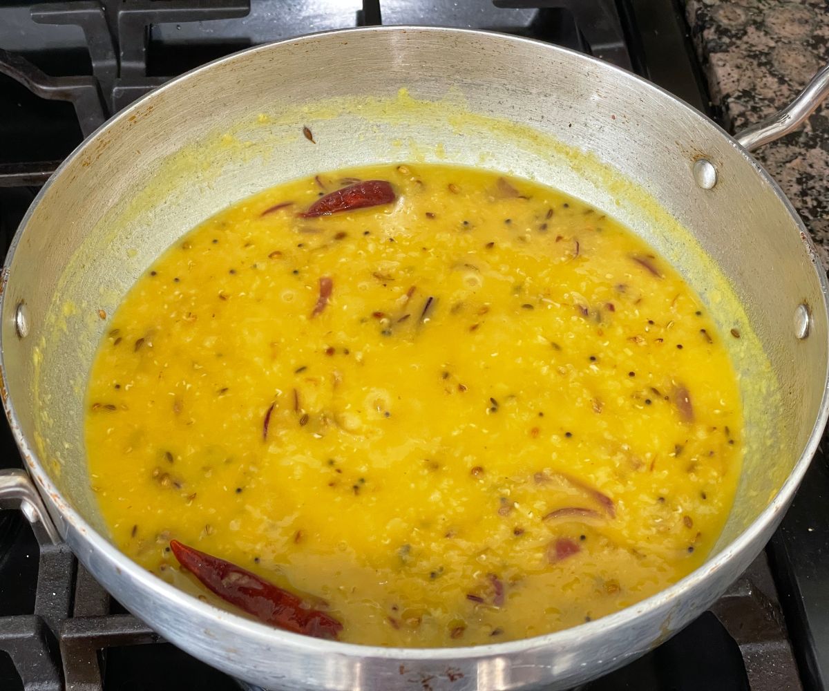 A pot of Bengali masoor dal is over the heat.