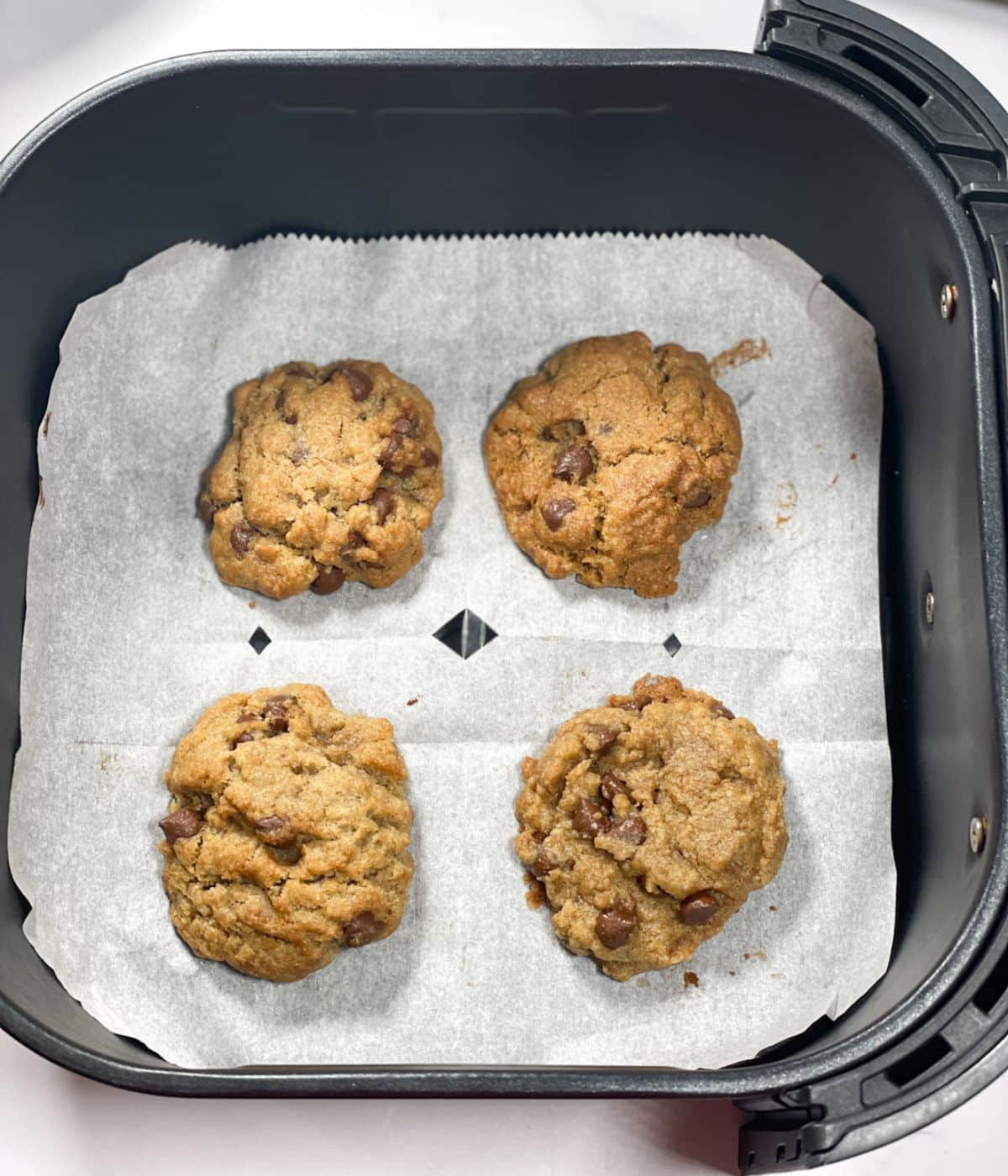 Air fryer basket is with vegan chocolate chip cookies.