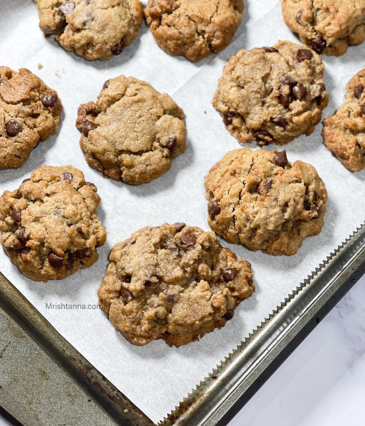 A baking tray is with air fried chocolate chip cookies.