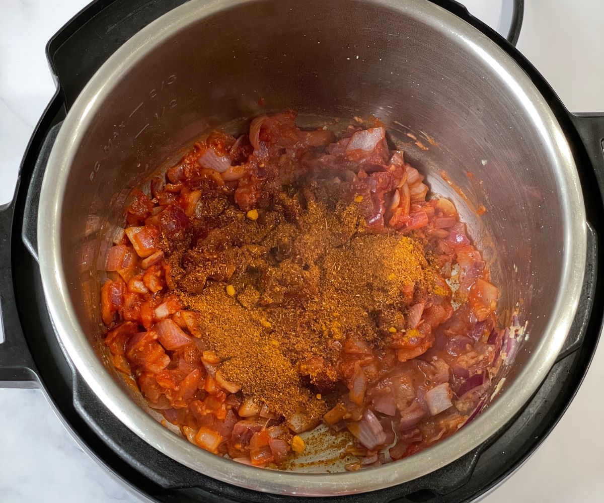 An instant pot is with spices, tomato paste for pav bhaji.