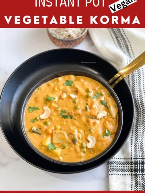 A bowl of vegetable korma is on the table and topped with cilantro.