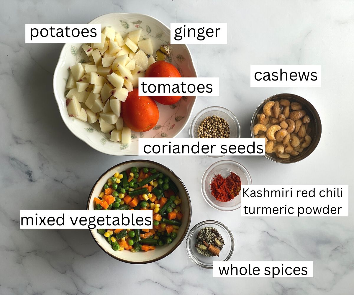 A table is covered with vegetable korma ingredients.