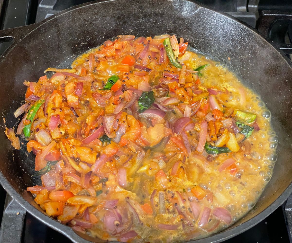 Cast iron pan is with idli masala over the heat.