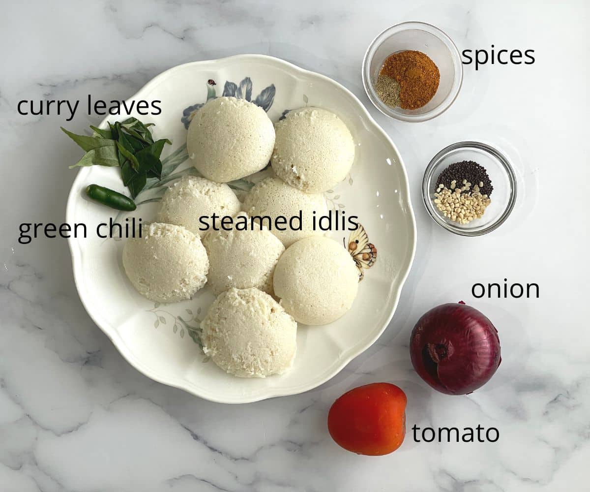 A plate of steamed idlis and other ingredients on the table for masala idli.
