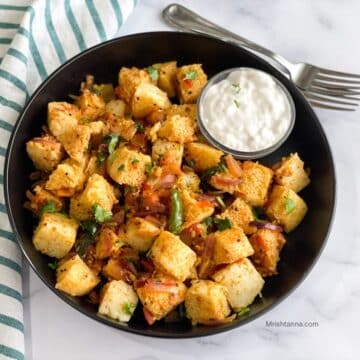 A plate of masala idli is on the table with forks.