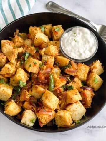 A plate of masala idli is on the table with forks.