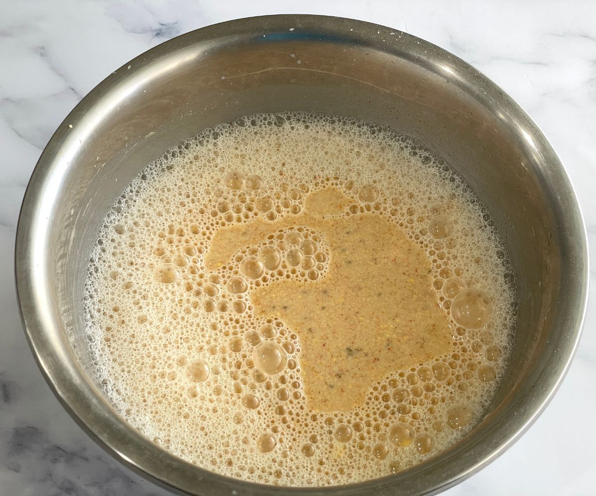 A bowl of kadhi mixture on the table.