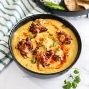 Close up of bowl filled with kadhi pakora curry.