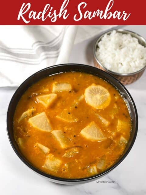 A bowl of Mullangi sambar is on the table with cloth and a small bowl of rice.
