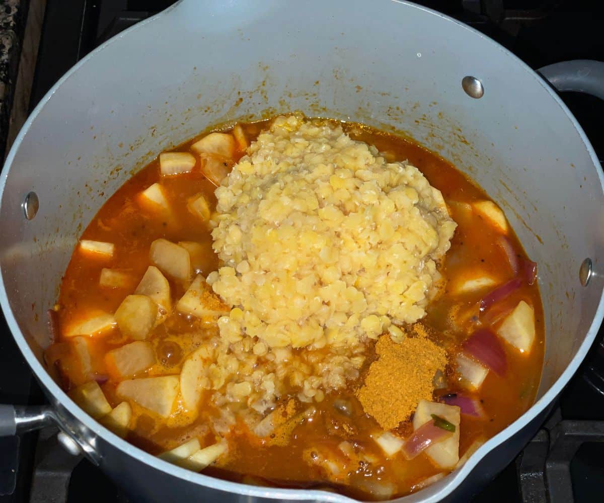 A pot is with Radish sambar mixture over the heat.