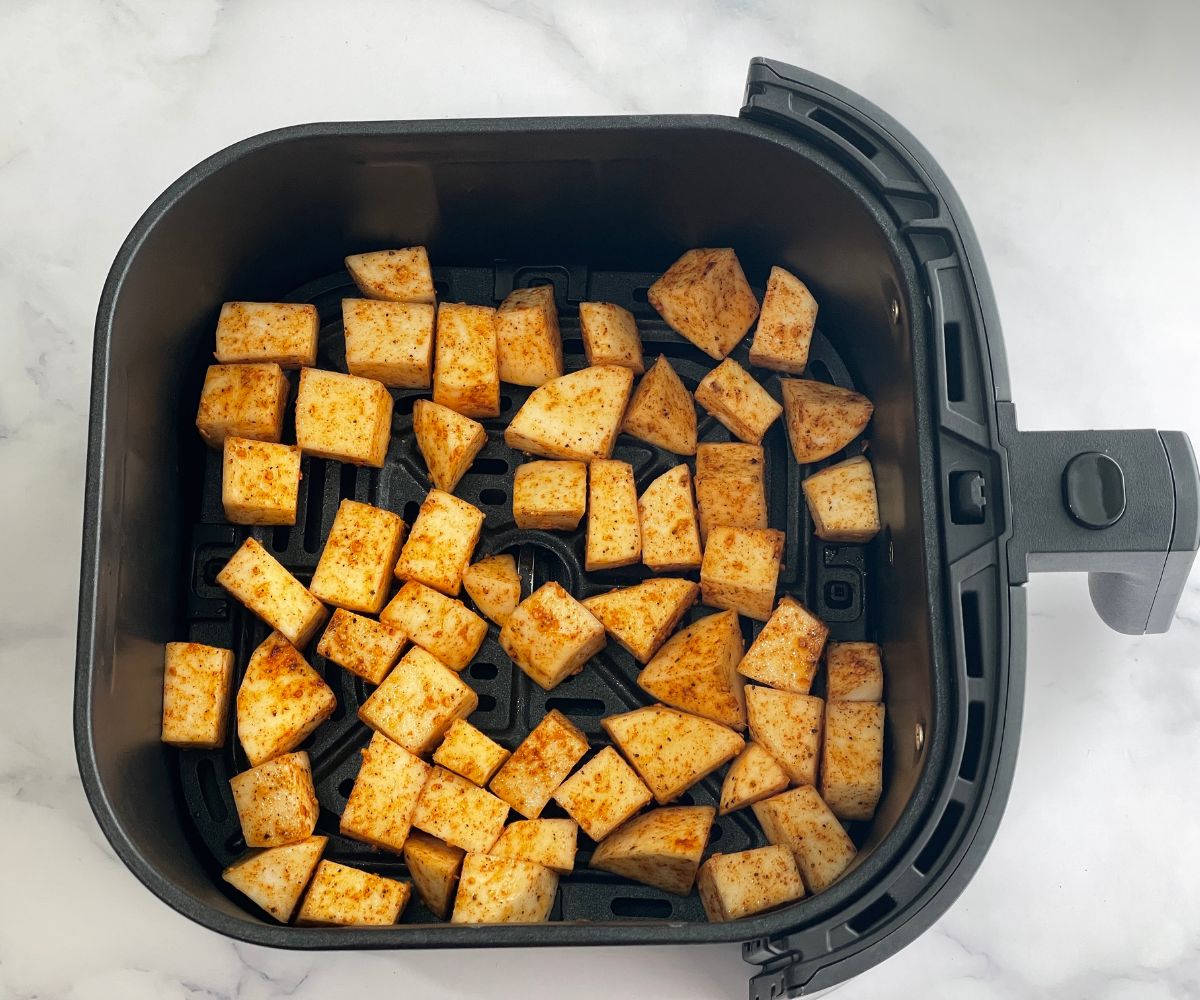 Air fryer basket is with turnips.