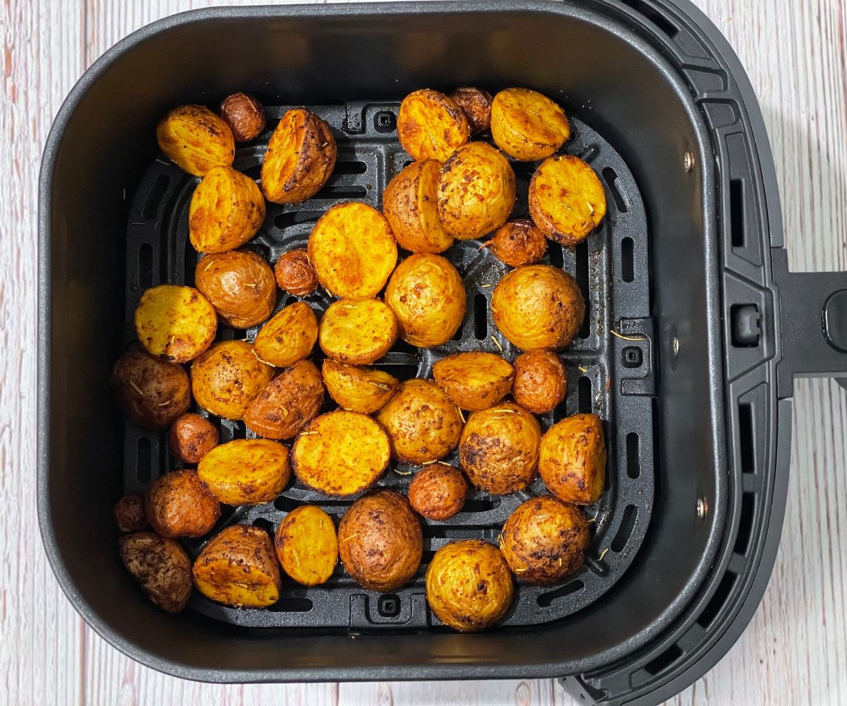 The air fryer basket is filled with roasted baby potatoes.