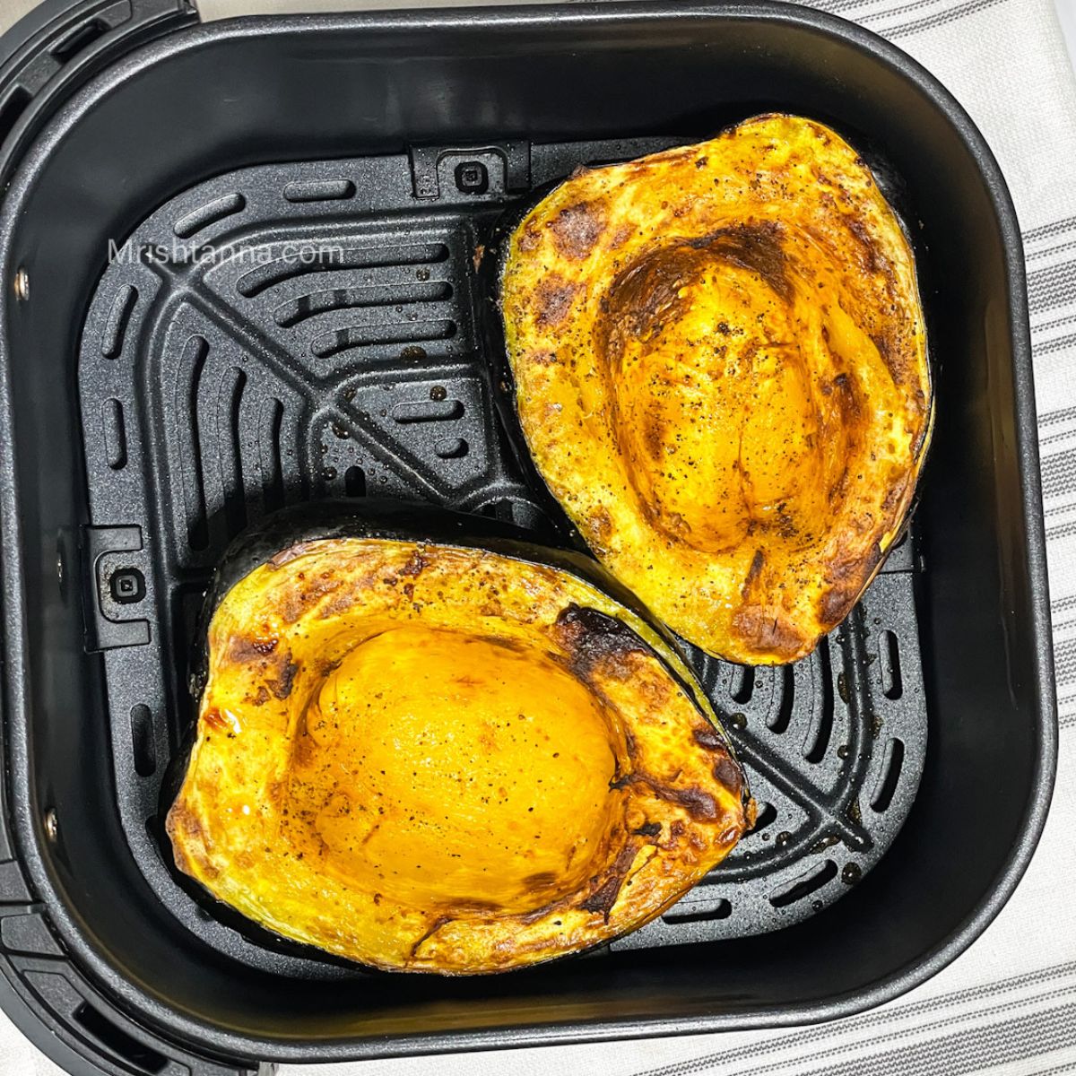 The air fryer roasted acorn squash is in the basket.