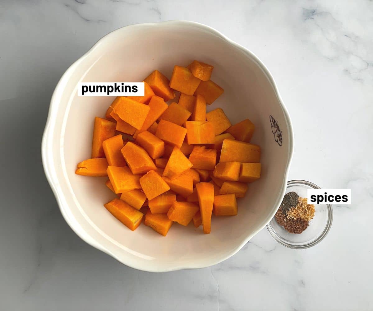 A bowl of pumpkins and spices are on the table.