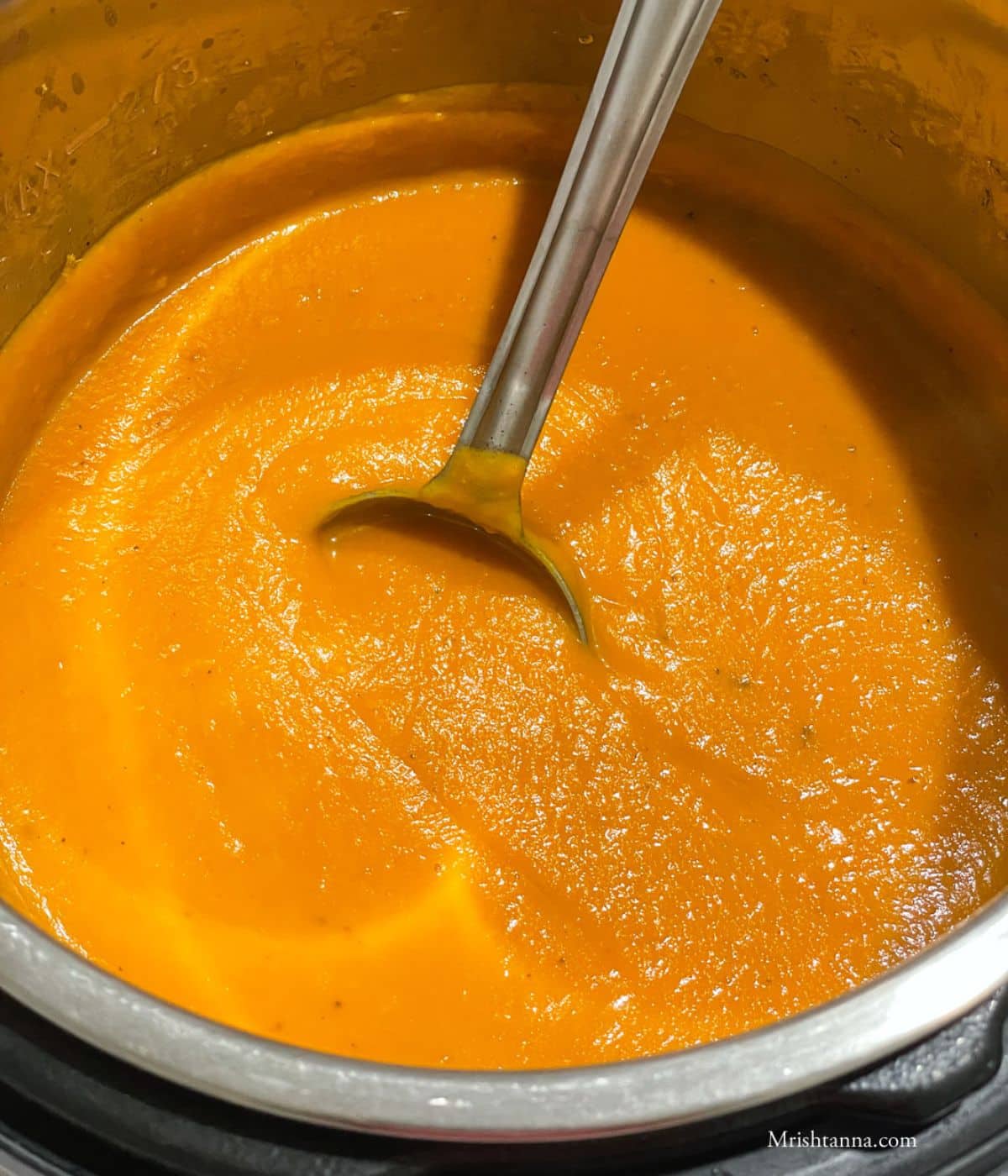 An instant pot is filled with butternut squash carrot ginger soup.