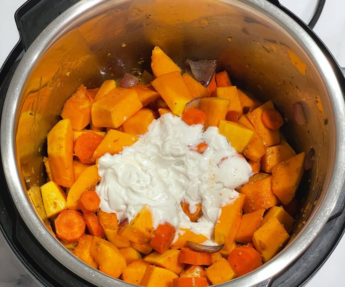 An instant pot is with butternut squash soup mixture.