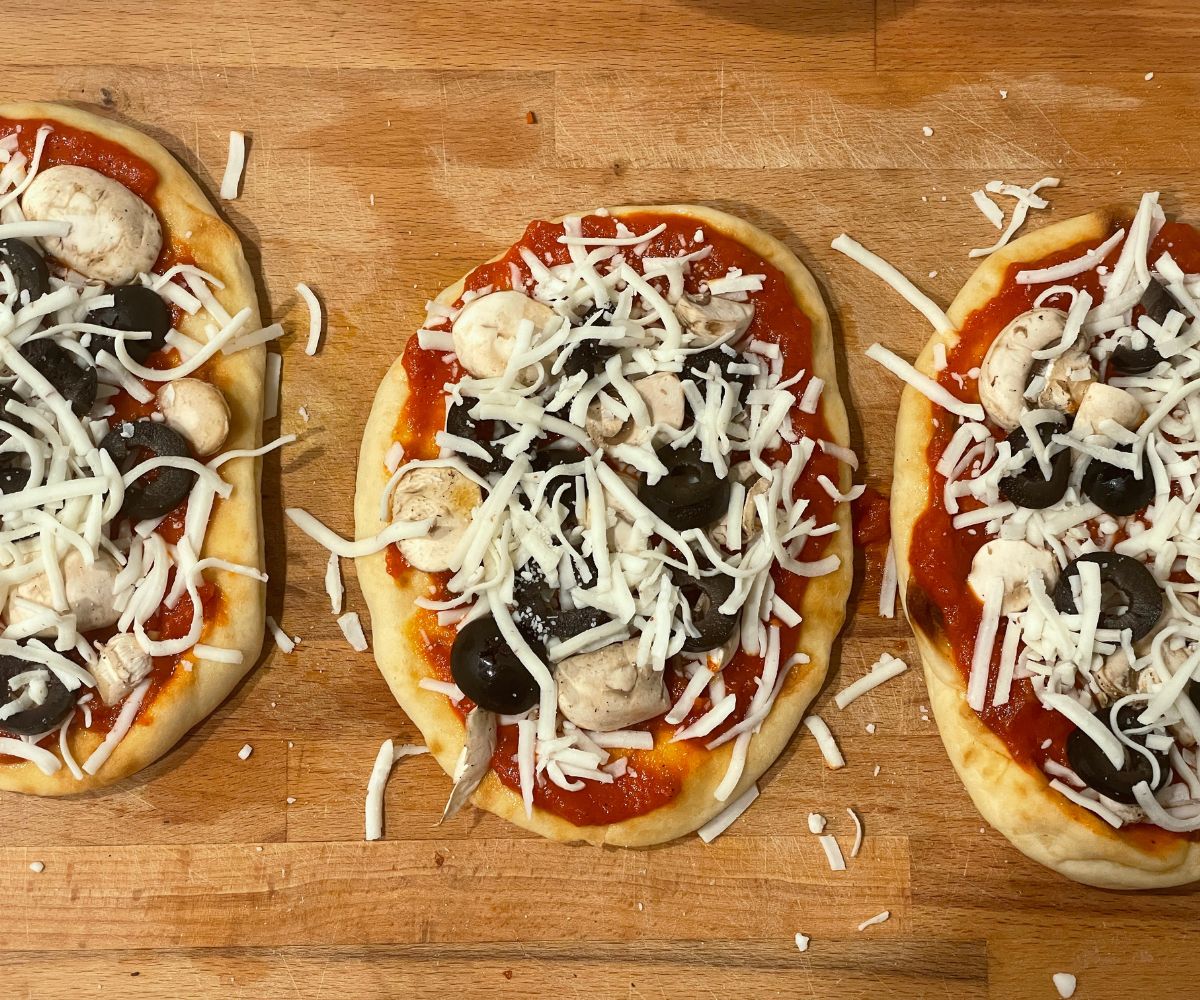 vegan naan is topped with mushrooms, olives and vegan cheese.