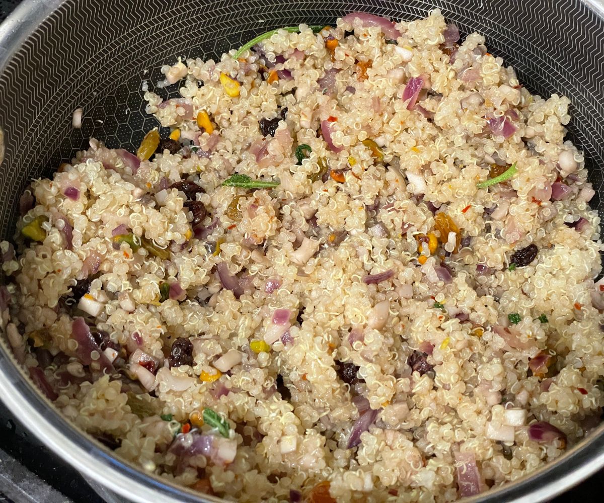 A pan is with quinoa stuffing over the heat.