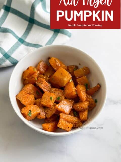 A bowl of roasted pumpkin is on the table.