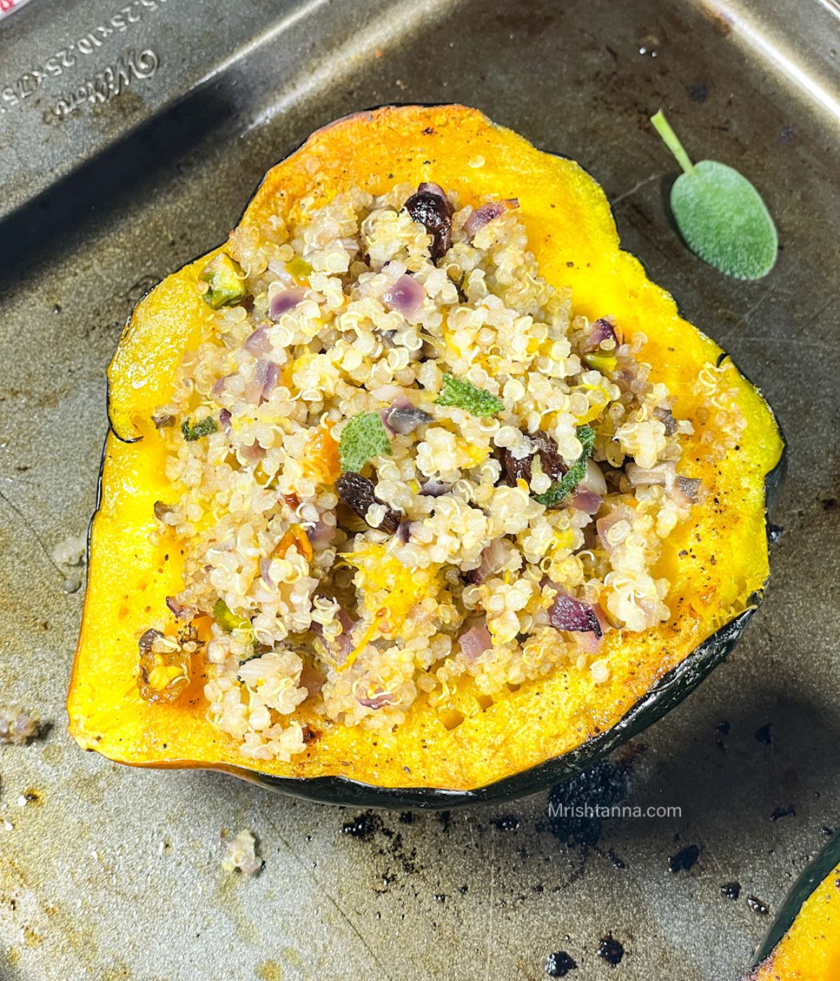 On the baking tray is quinoa stuffed with acorn squash.