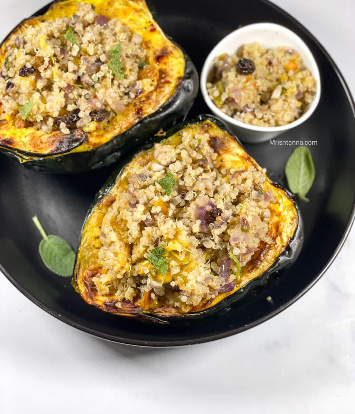 A plate is with vegan stuffed acorn squash with quinoa.