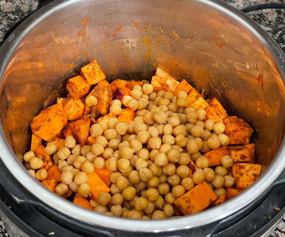A pot is with sweet potatoes and chickpeas for curry.