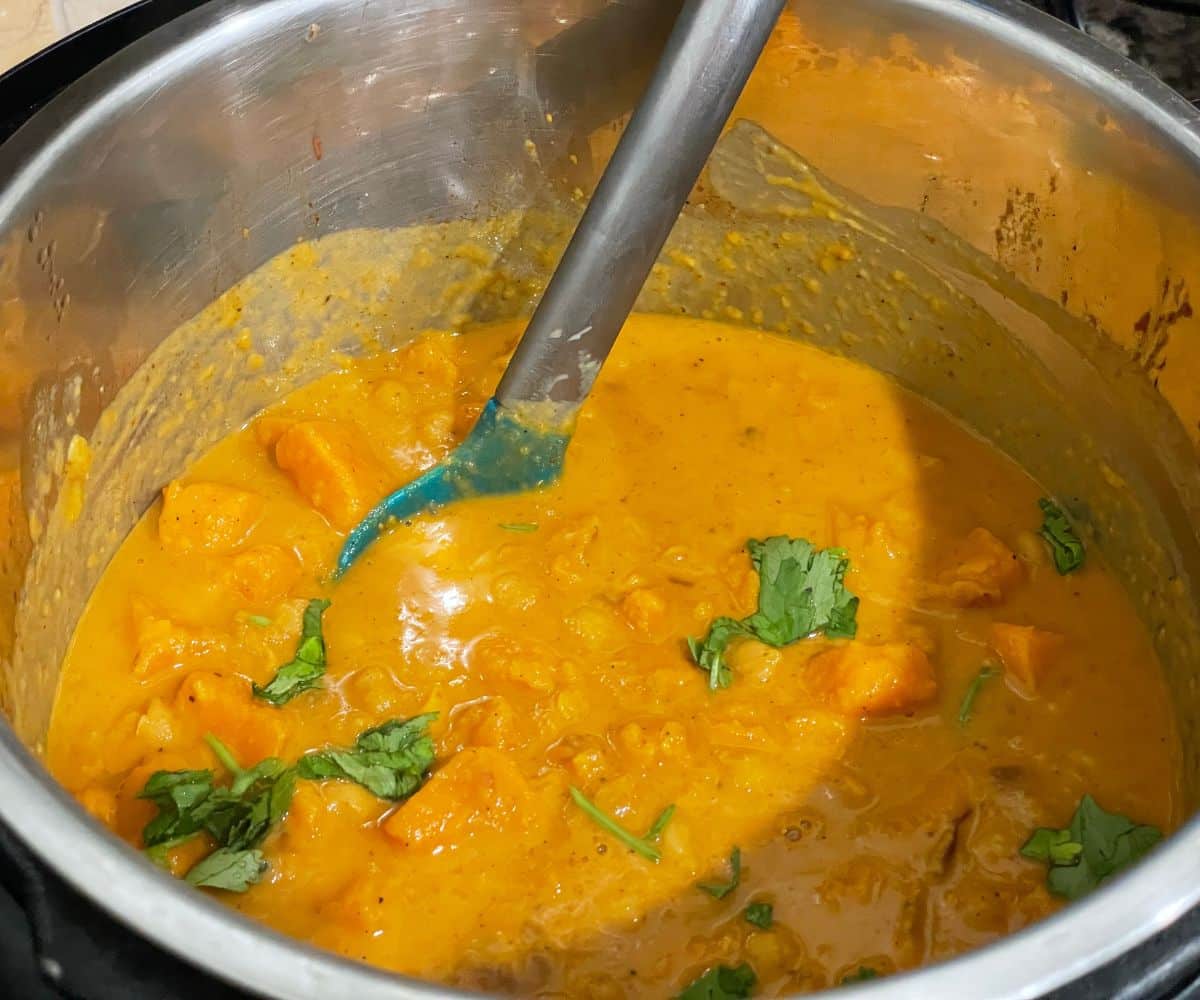 A pot of sweet potato curry is on the counter top.