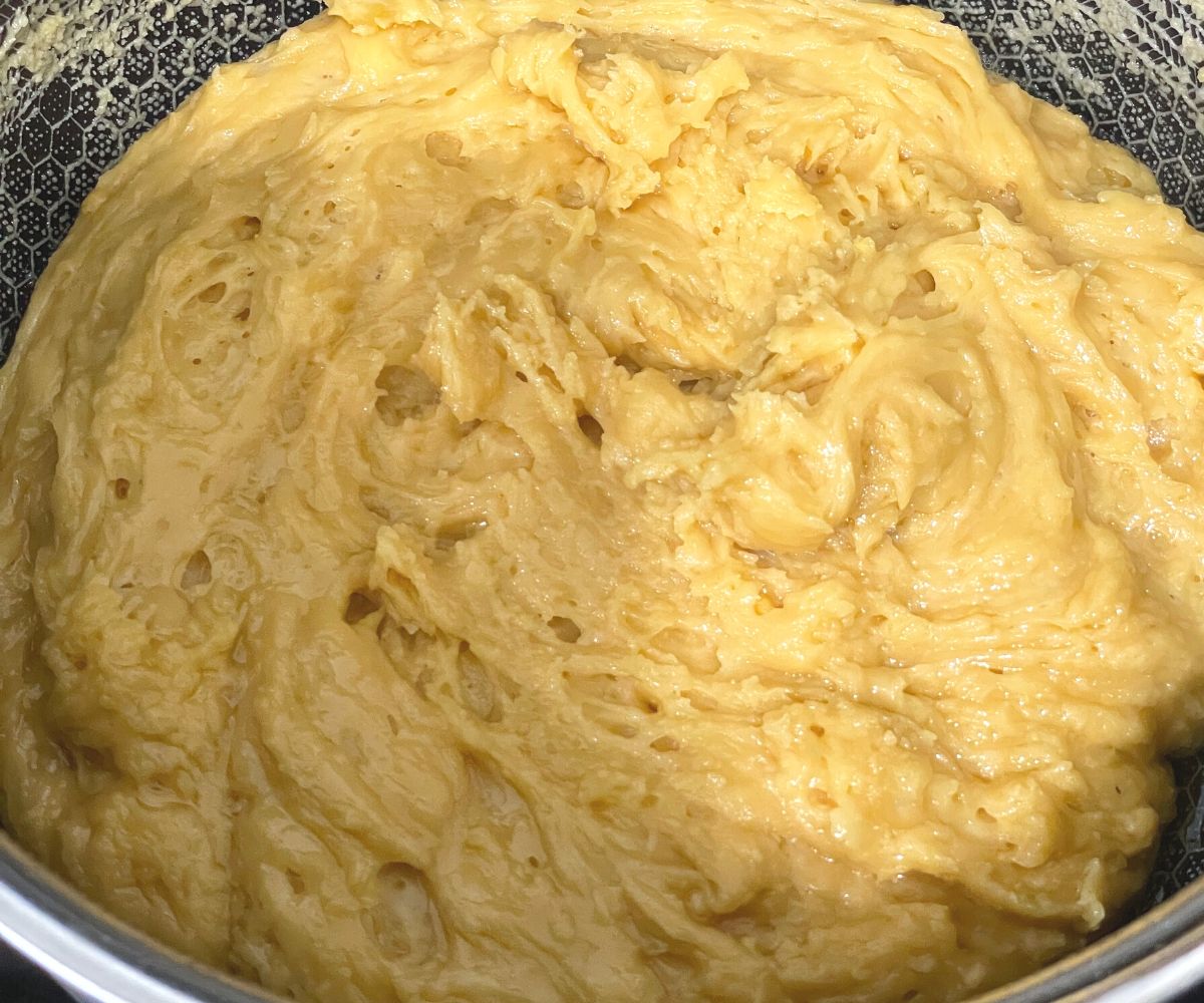 A pan is with mysore pak mixture over the heat.