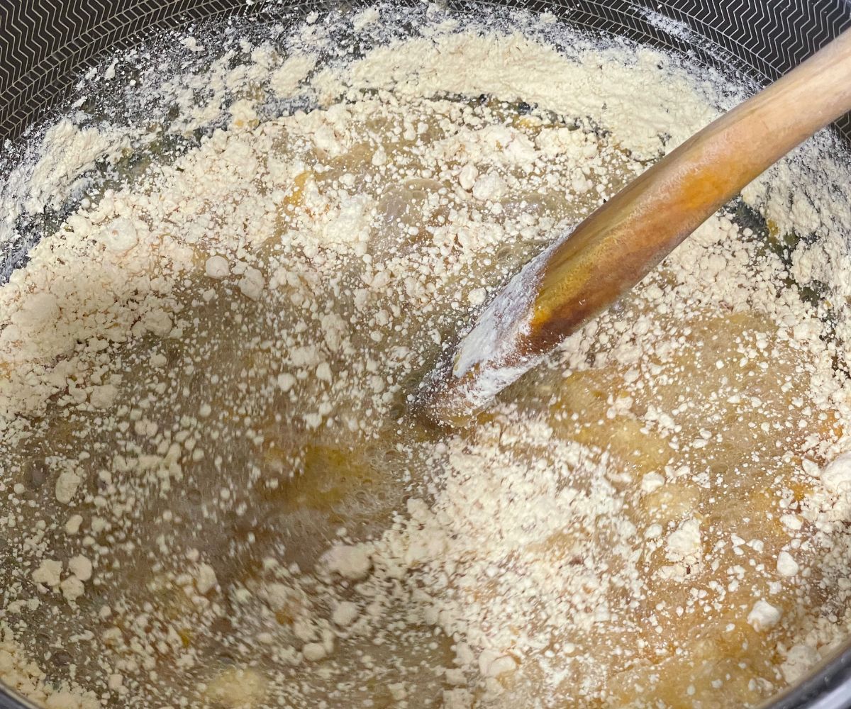 A pan is with sugar syrup and besan flour over the heat.