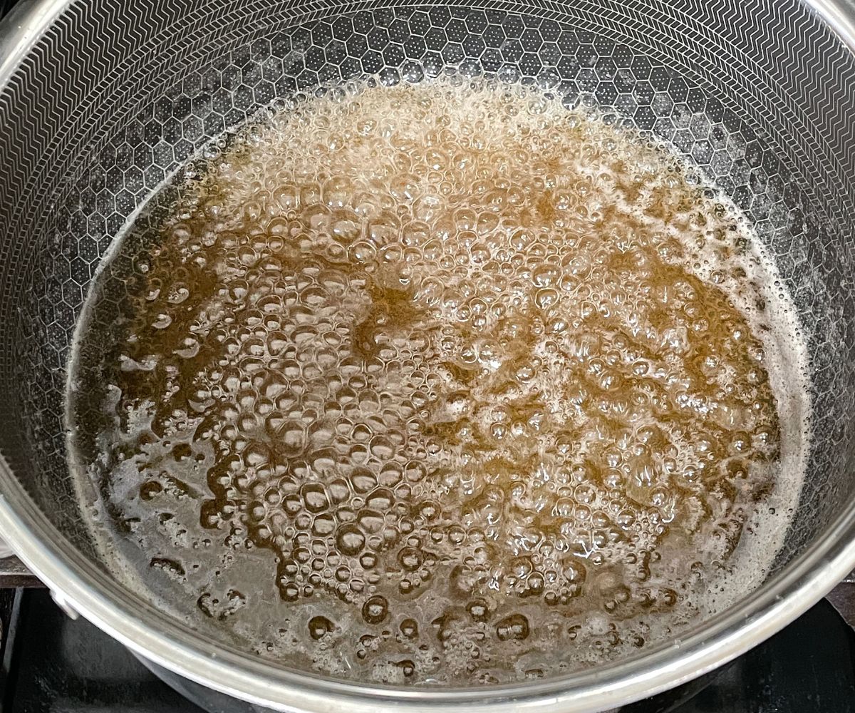 A pan is with sugar syrup over the heat.