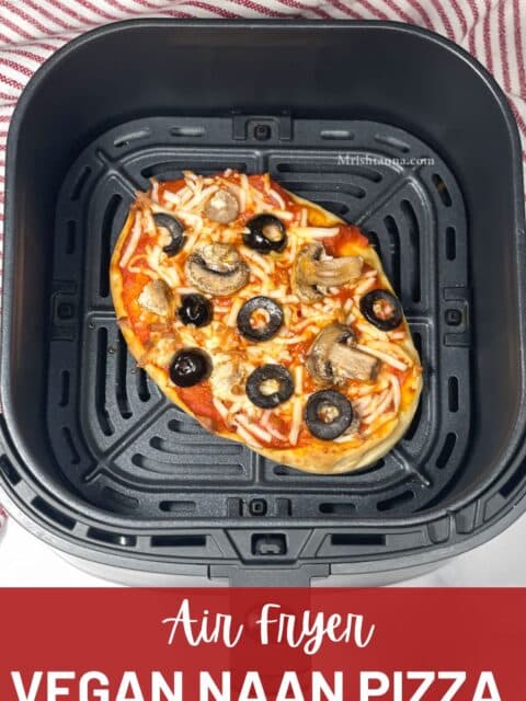 Air fryer basket is with vegan naan pizza.