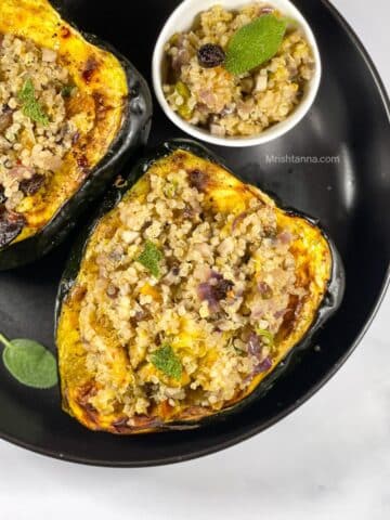 A plate of vegan quinoa stuffed acorn squash is on the table.
