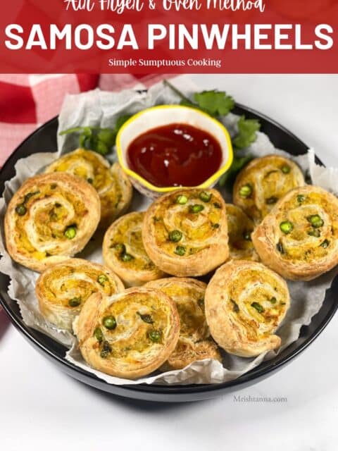 A plate of samosa pinwheels are on the table with ketchup sauce.