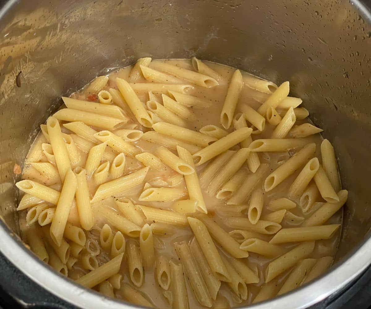 An instant pot with cajun pasta on cooking mode.