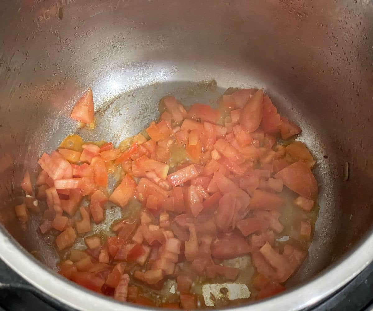 A pot with chopped tomatoes on saute mode.