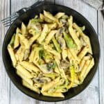 A plate of vegan Cajun Pasta is on the wooden table.