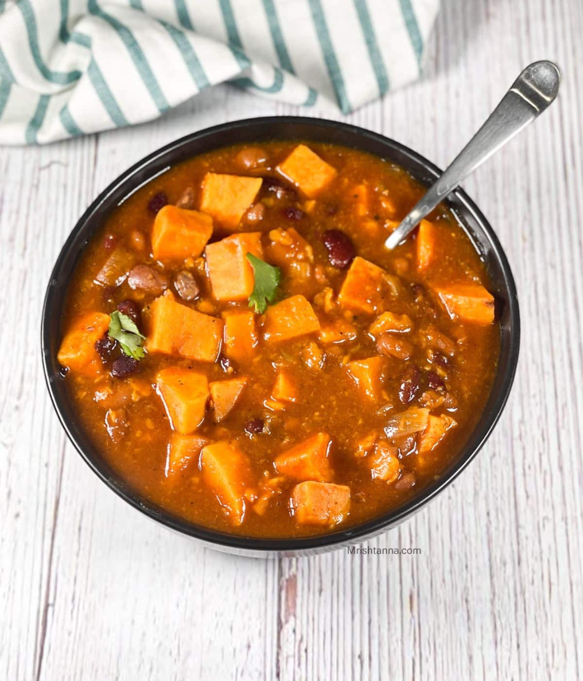 A bowl of sweet potato chili is on the table.